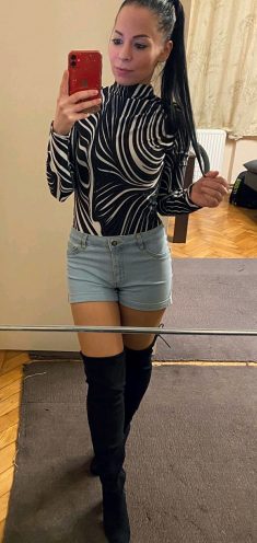 Sexy brunette in dress shirt, short jean shorts and knee high leather boots